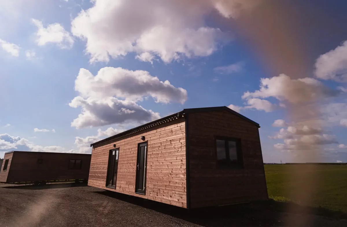 Dřevěný mobilní domek ABODES na pozemku.