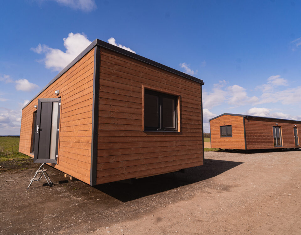 Dřevěné mobilní domy ABODES na pozemku.